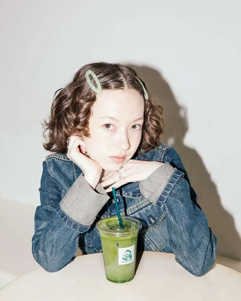 A guest with an iced matcha latte at the pop-up
